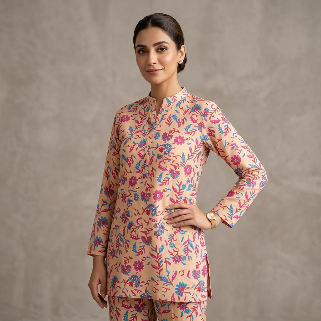 Woman wearing a floral patterned kurta with a plain background