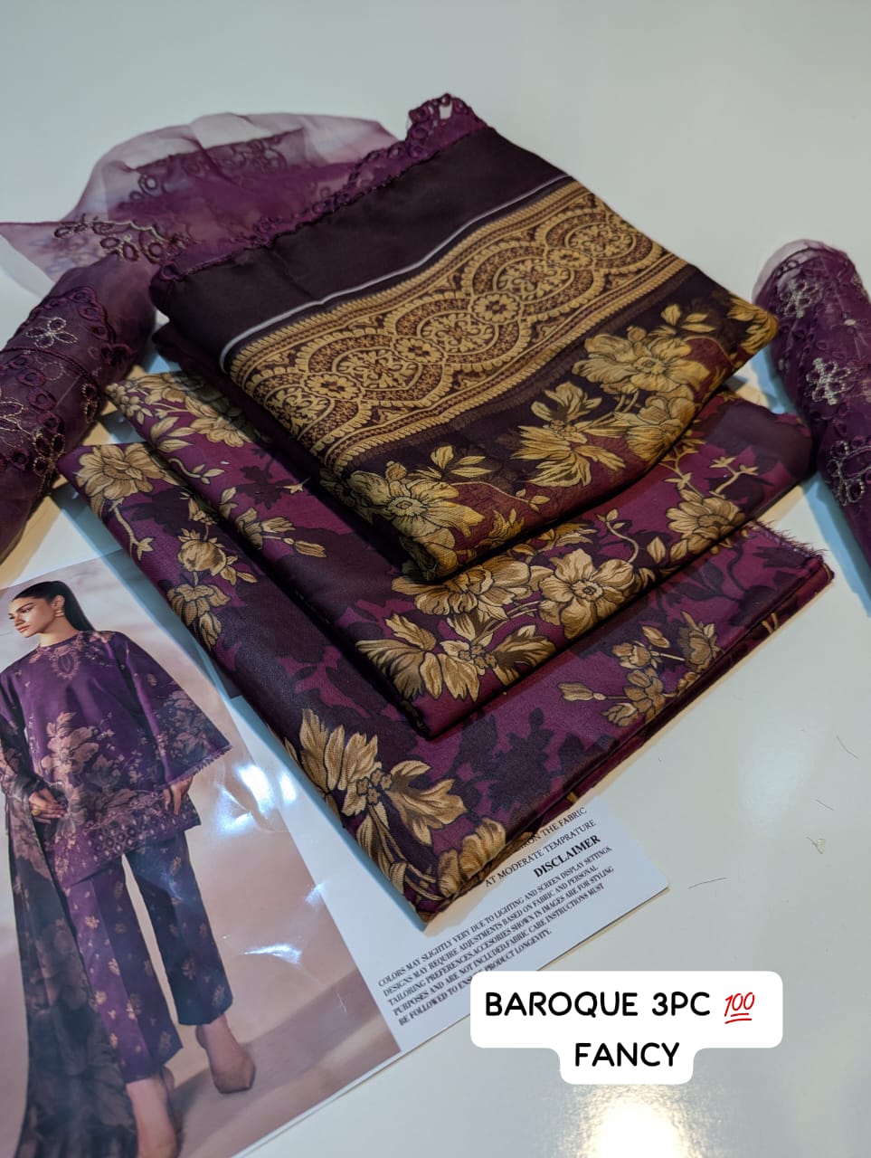 Purple and gold fabric with a pattern, displayed with a model and product name label.