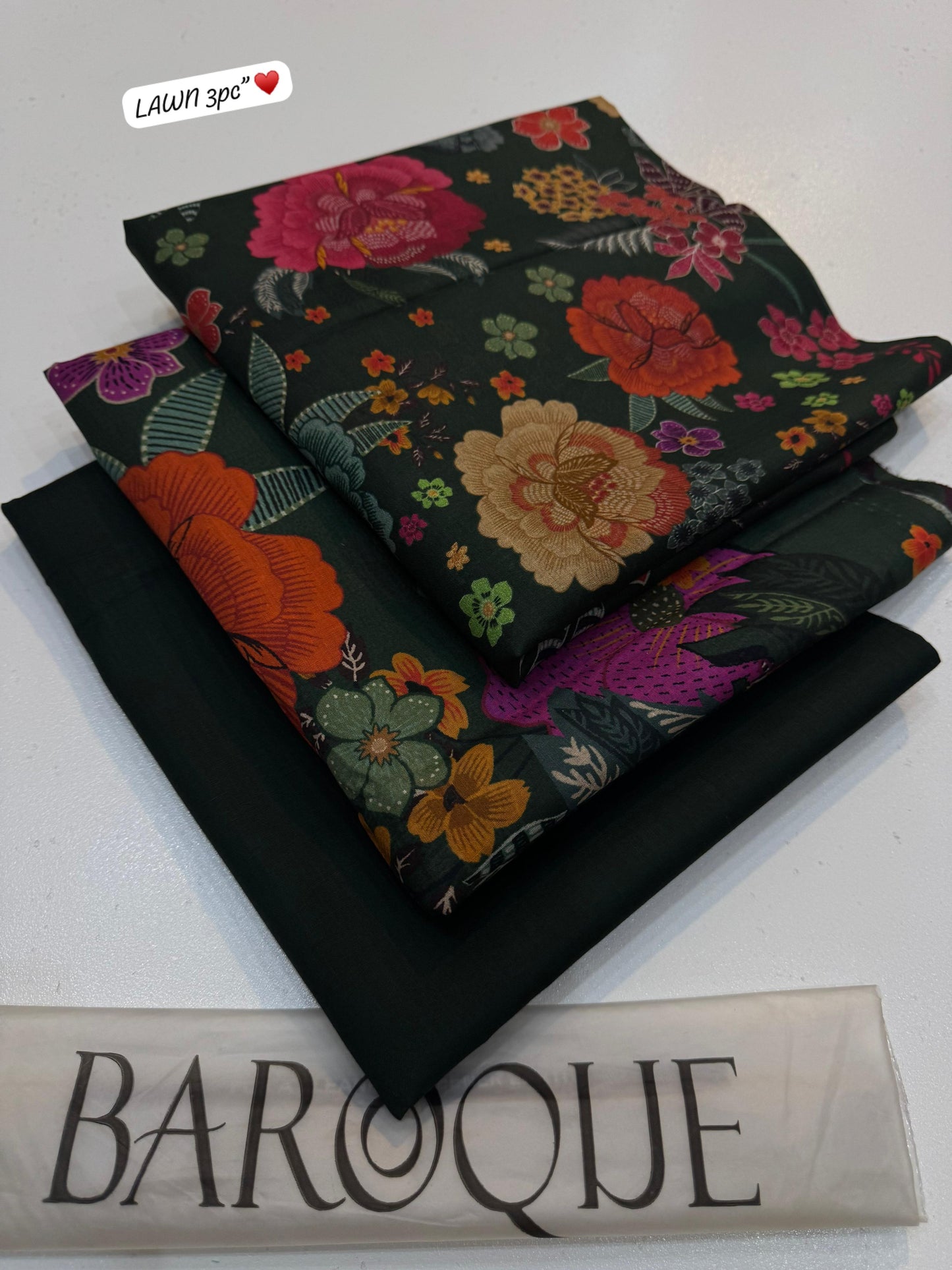 Floral fabric with embroidery on a black background, featuring the brand 'Lawn 3pc'.