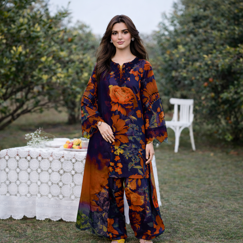 Woman in a floral outfit standing outdoors with greenery and a table in the background