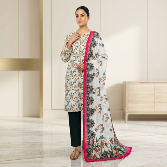 Woman wearing a floral dress with a pink border in a minimalistic room.