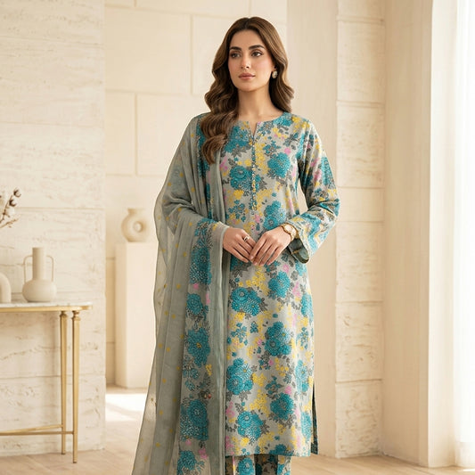 Woman wearing a floral dress with a light gray dupatta in a bright room.