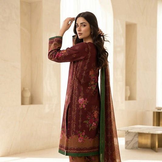 Woman wearing a maroon embroidered dress with a green dupatta in an elegant interior setting.