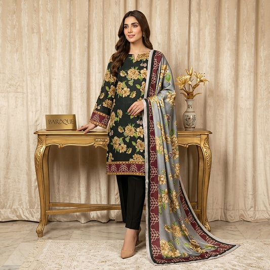 Woman in floral dress and dupatta standing next to a decorative table with a vase.