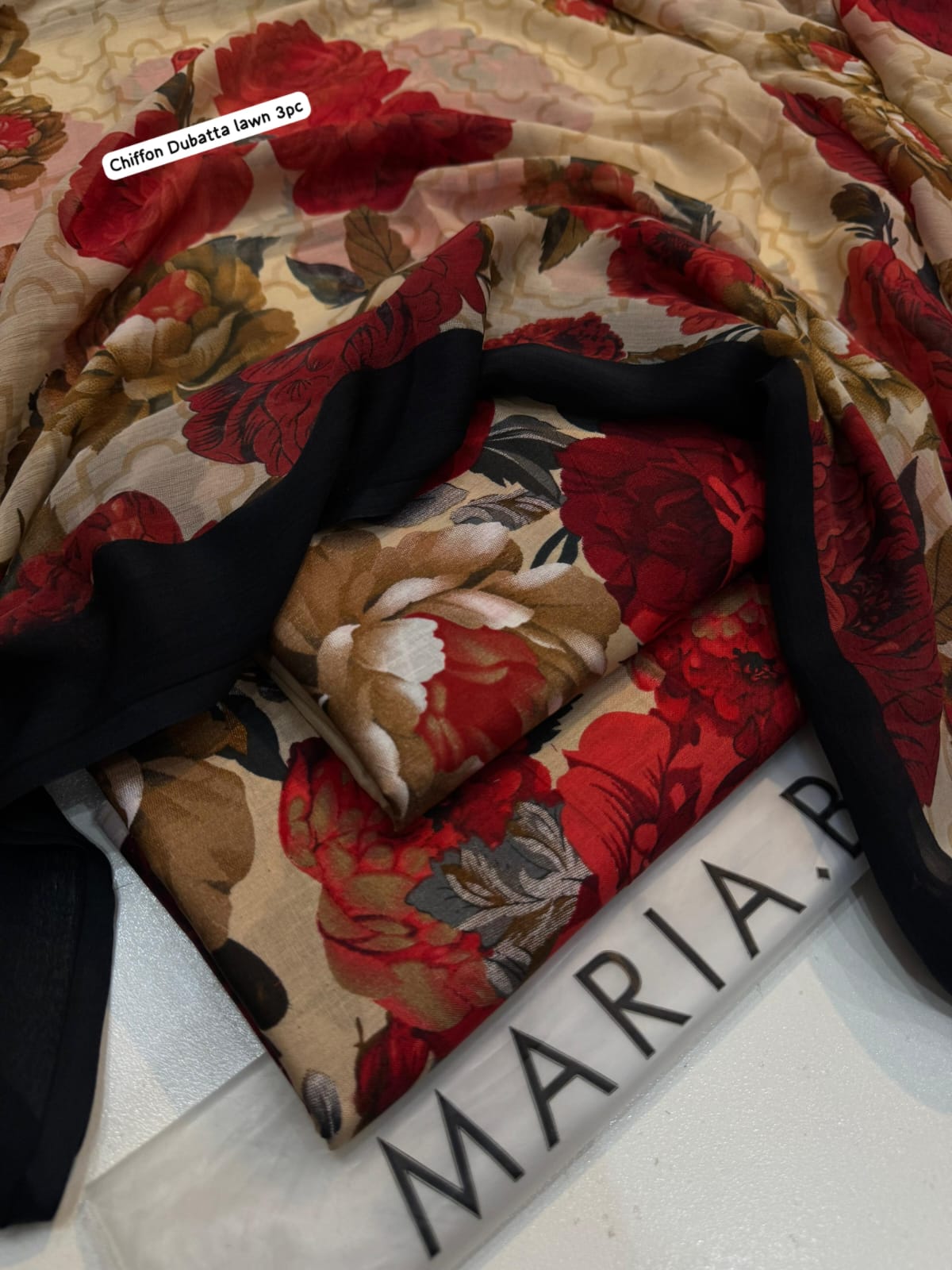 Floral fabric with red and beige flowers on a black background, with 'Maria' branding.