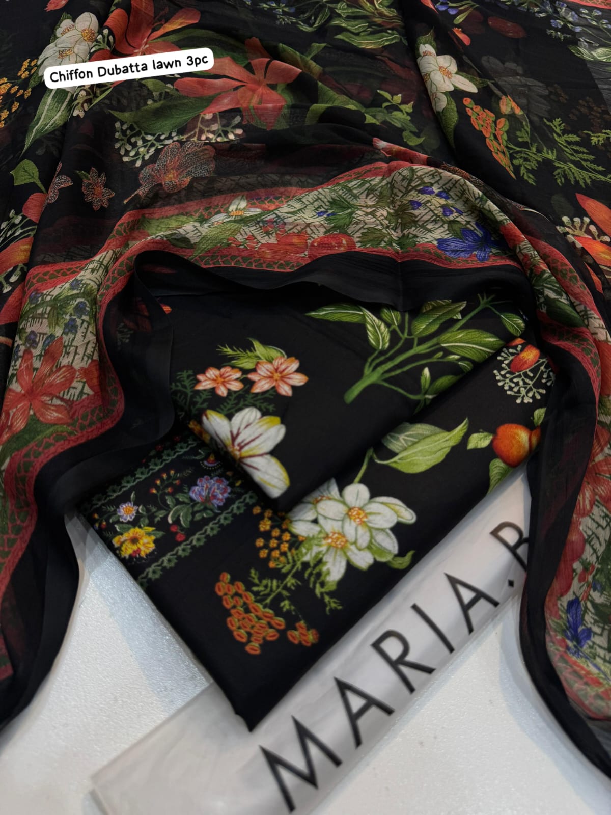 Floral fabric with colorful patterns on a black background, branded 'Maria'.