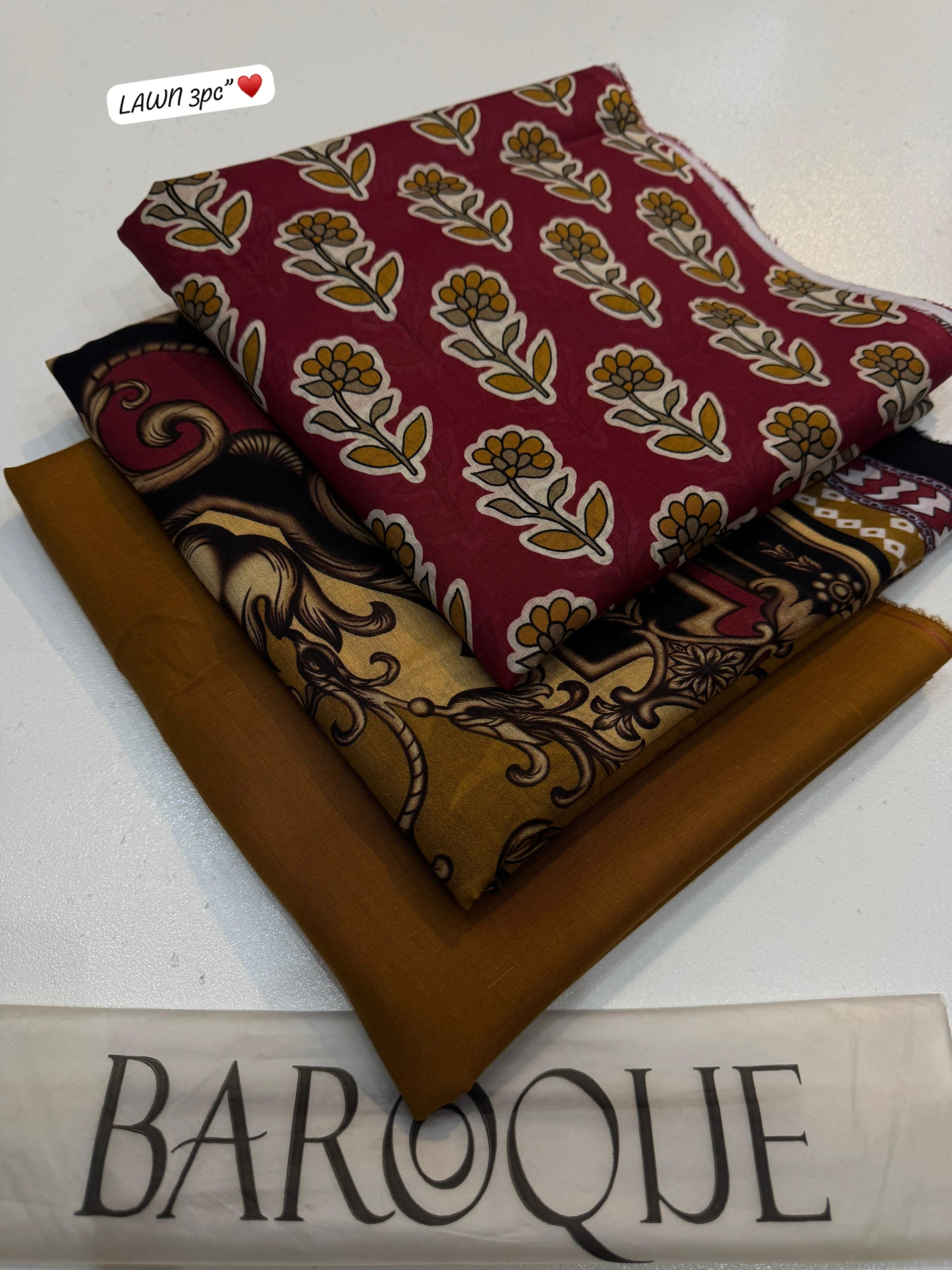 Stack of fabric swatches with patterns and a brown swatch labeled 'Baroque' on a white background.