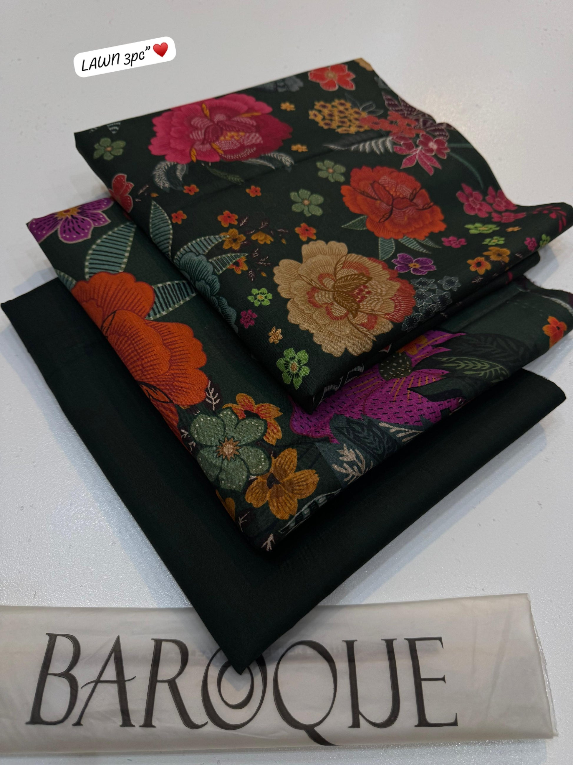 Floral fabric with embroidery on a black background, featuring the brand 'Lawn 3pc'.
